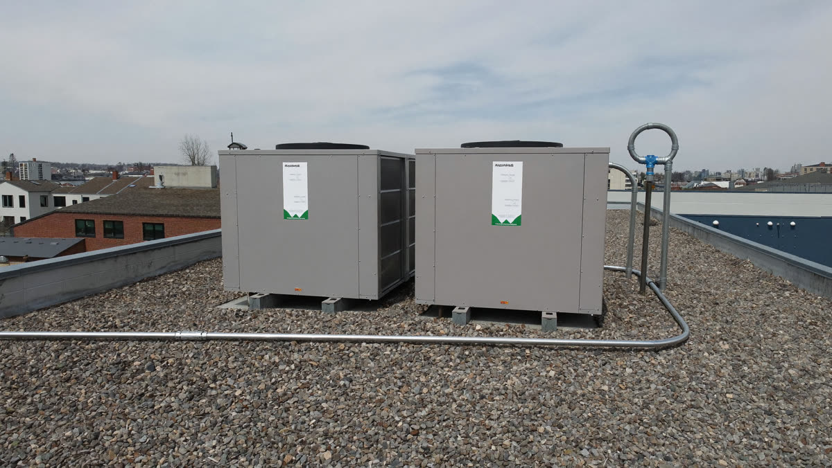 Rooftop HVAC units on a commercial flat roof under an overcast Alberta sky